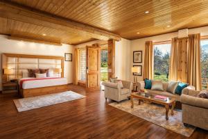 a bedroom with a bed and a living room at Baragarh Resort & Spa, Manali- IHCL SeleQtions in Manāli