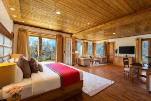 Baragarh Resort & Spa, Manali- IHCL SeleQtions في مانالي: غرفة نوم مع سرير وغرفة معيشة