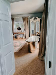 a bathroom with a tub in the corner of a room at Verzon House in Ledbury