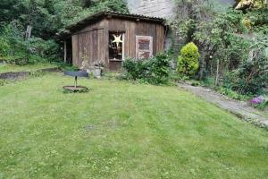 a shed in a yard with a grill in the grass at Ferienwohnung Katharina in Stolberg (Harz) in Stolberg