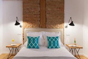 a bedroom with a bed with a brick wall at Apartamento en el centro la ciudad in Madrid