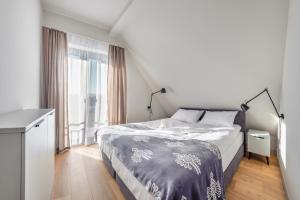 a bedroom with a bed and a large window at Apartamenty Sun & Snow Resorts A Białka Tatrzańska z sauną in Białka Tatrzańska