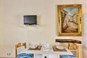 a table with two chairs and a tv on a wall at Casale Pozzo al Moro in Marina di Campo