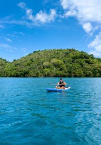 a man is sitting on a kayak in the water at The Hawk's Nest Resort in Sabang