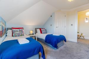 two beds in a room with blue and red at Brunswick Fab Pad - By My Getaways in Brighton & Hove