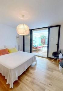 1 dormitorio con cama blanca y ventana grande en Calme et apaisant en La Saline les Bains