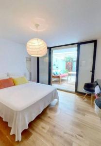 a bedroom with a white bed and a large window at Calme et apaisant in La Saline les Bains