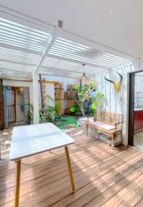 a patio with a table and a bench on a deck at Calme et apaisant in La Saline les Bains