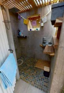 a small bathroom with a sink and a tiled floor at Calme et apaisant in La Saline les Bains