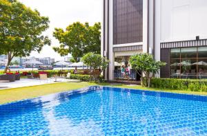 a swimming pool in front of a building at Ibis Bangkok Riverside in Bangkok