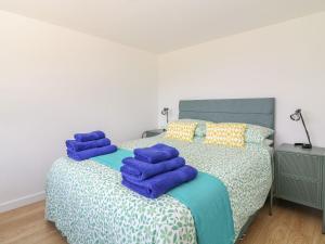een slaapkamer met een bed met blauwe handdoeken bij Bailey Cottage in Truro