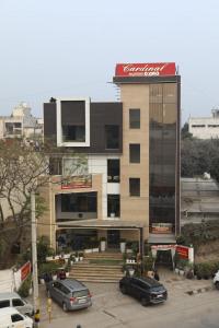 un edificio con auto parcheggiate in un parcheggio di Cardinal Express Oxmo a Nuova Delhi