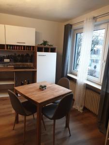 a kitchen with a wooden table and chairs and a window at Ferienwohnung Luitpold 2 in Memmingen