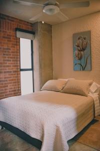 a bed in a room with a brick wall at Bunde Haus Hotel EXPRESS BOUTIQUE in Ibagué