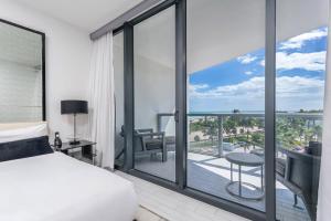 een slaapkamer met een bed en een balkon bij Ocean View Residence at W South Beach -514 in Miami Beach