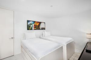 une chambre blanche avec un banc blanc et une photo sur le mur dans l'établissement Ocean View Residence at W South Beach -514, à Miami Beach