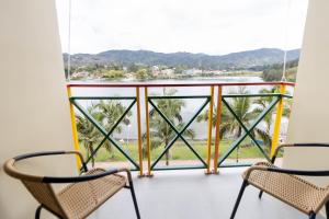 a balcony with chairs and a view of the water at Casa García Rent Home in Guatapé