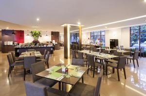 a dining room with tables and chairs and a restaurant at Ibis Bangkok Riverside in Bangkok