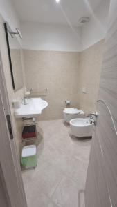 bagno con 2 lavandini, vasca e servizi igienici di ValGiuSi Resort a Capo Vaticano