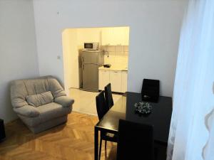 ein Wohnzimmer mit einem Stuhl und einem Tisch in der Unterkunft Apartment Bitola in Bitola
