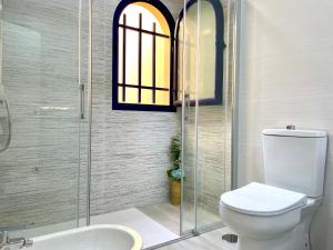 a bathroom with a toilet and a glass shower at Bahia Meloneras Vista Golf in Meloneras +20 photos