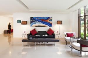 a living room with a couch and a painting on the wall at Ibis Bangkok Riverside in Bangkok