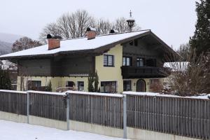 a house with a fence in the snow at Landhaus-Appartements Warraich in Schladming