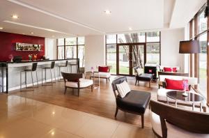 a living room with a bar and some chairs at Ibis Bangkok Riverside in Bangkok