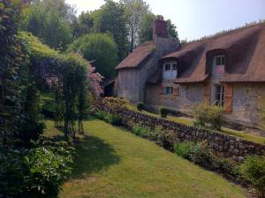 an old stone house with a stone wall at La Chaumière - petit-déjeuner inclus à 15 min de Versailles in Jouars-Pontchartrain