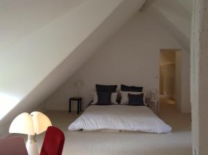 Dormitorio blanco con cama en el ático en La Chaumière - petit-déjeuner inclus à 15 min de Versailles en Jouars-Pontchartrain