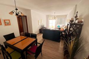 een woonkamer met een tafel en een bank bij Apartamento a unos pasos de la Playa (Rota) in Rota