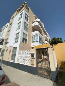 een groot gebouw met een poort ervoor bij Apartamento a unos pasos de la Playa (Rota) in Rota