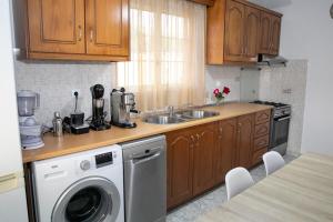 a kitchen with a sink and a washing machine at Maria’s House Arillas Corfu in Arillas