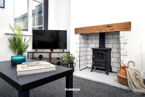 a living room with a fireplace and a tv at Chorlton House by Truestays - NEW 2 Bedroom House in Stoke-on-Trent in Hanley