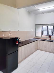 uma cozinha com um frigorífico preto num quarto em Gaya Homestay 3Bed 2Bath 12pax Taman Gaya JB 5min to Aeon&Ikea 高雅民宿 em Ulu Tiram