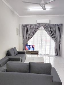 una sala de estar con 2 sofás y una ventana grande en Gaya Homestay 3Bed 2Bath 12pax Taman Gaya JB 5min to Aeon&Ikea 高雅民宿, en Ulu Tiram