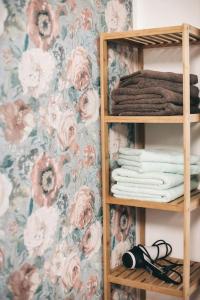 a book shelf with towels and a floral wallpaper at Ferienhaus an der Wiederitz in Freital
