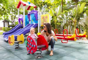 a woman and a baby playing on a playground at Ibis Bangkok Riverside in Bangkok