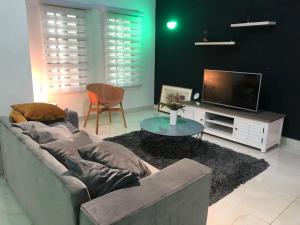 a living room with a couch and a tv at PARADISE HY in Cotonou