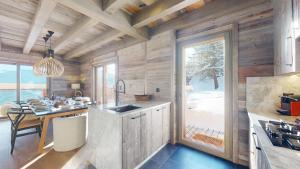 a kitchen with wooden walls and a large window at Ecureuil noir COSY & QUIET chalet 10 personnes in Vex