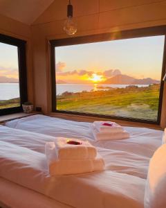 1 dormitorio con 2 toallas en una cama y ventana grande en Kråen Gard en Larsnes