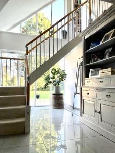 sala de estar con escalera y maceta en The Thorpe Guesthouse en Huntingdon