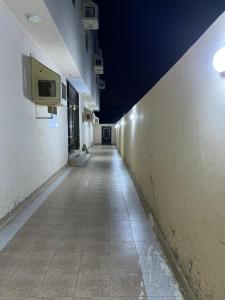 an empty hallway in a building with a tv on the wall at AlSultan Apartments in Umm Lujj