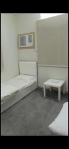 a room with two beds and a table in it at AlSultan Apartments in Umm Lujj