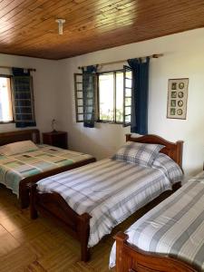 2 Betten in einem Zimmer mit 2 Fenstern in der Unterkunft Finca Brisas del Pacifico in Montenegro