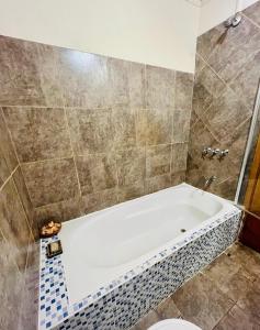 een badkamer met een bad en een toilet bij Casa Jaguar in Puerto Iguazú