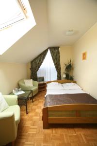 ein Schlafzimmer mit einem Bett, einem Sofa und einem Fenster in der Unterkunft Pokoje hotelowe Azyl in Kąty Wrocławskie
