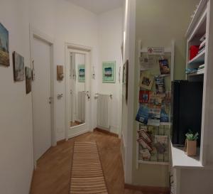 un pasillo con paredes blancas y suelo de madera y una habitación en VentoVerde B&B, en Albenga