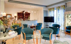 a living room with blue chairs and a tv at Romantik Hotel Gasthaus Rottner in Nuremberg