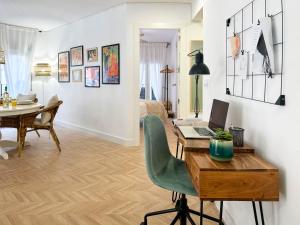 a living room with a desk with a laptop on it at Elegante apartamento a unos pasos de la Rambla. in Alicante